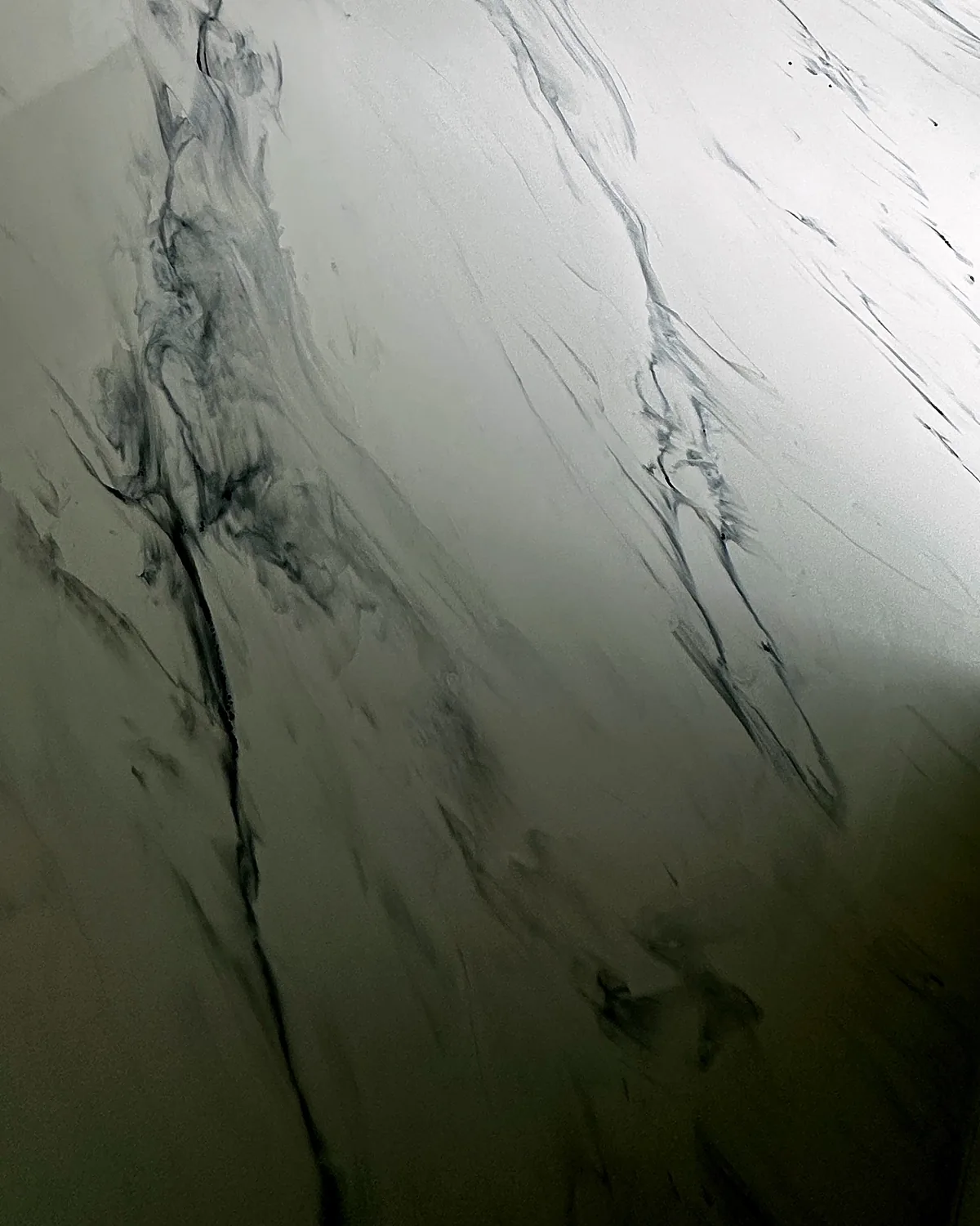 Detail šedého žilkování na bílé lité podlaze