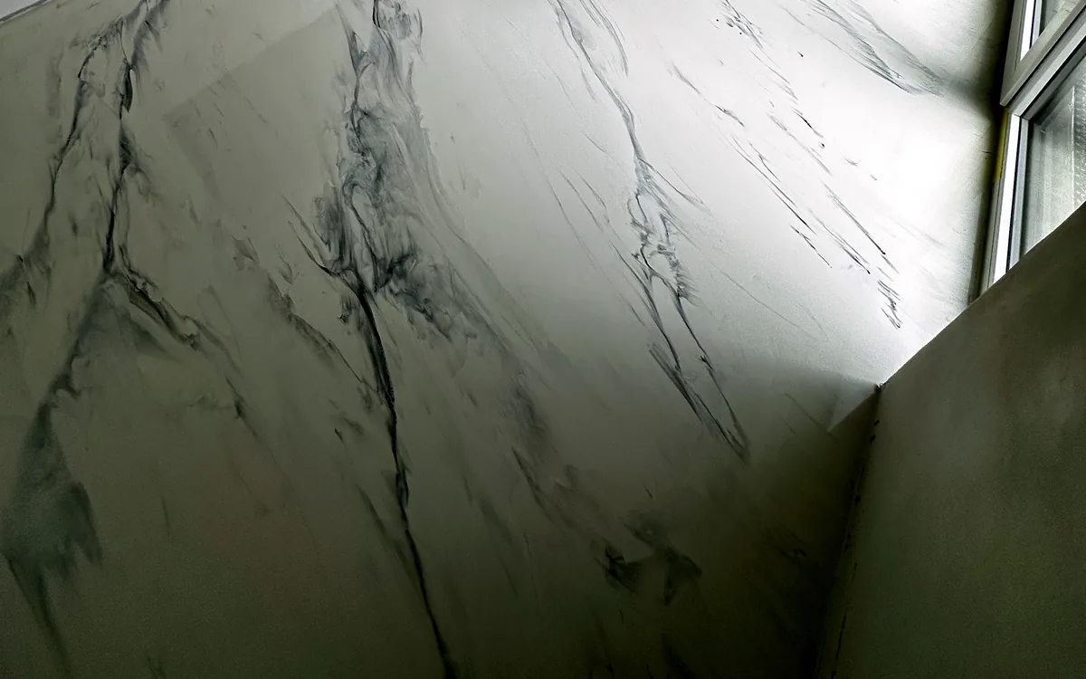 Detail bílé lesklé lité podlahy s šedým žilkováním