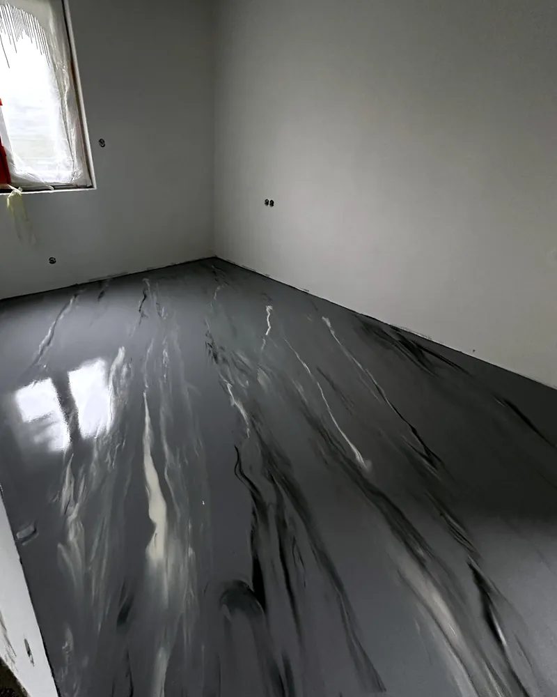 Hotová šedá lesklá litá podlaha s bílým žilkováním v menším pokoji