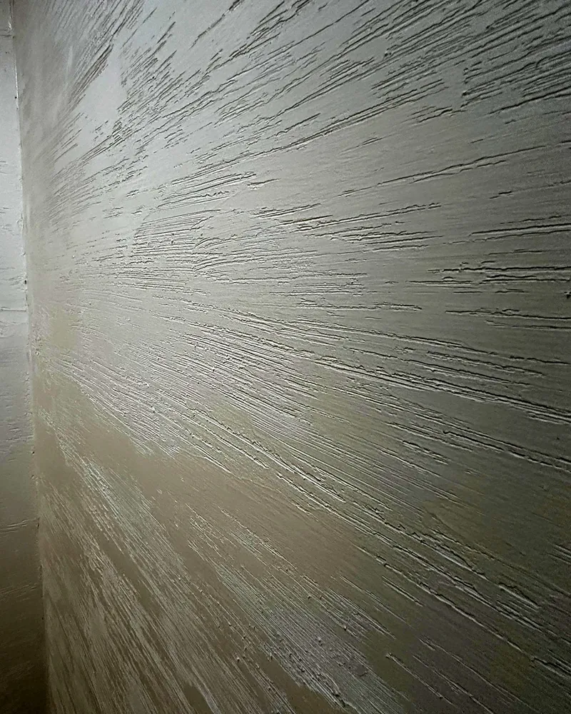 Detail světlé strukturované stěrky s tahy hladítka na stěně